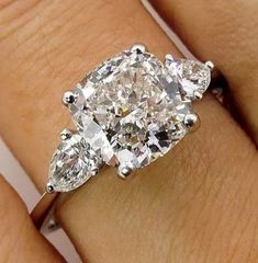 a woman's engagement ring with three pear shaped diamonds