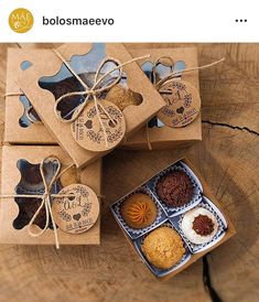 four boxes with different types of cookies in them on top of a wooden table next to each other