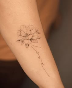 a woman's arm with a flower tattoo on the left side of her arm