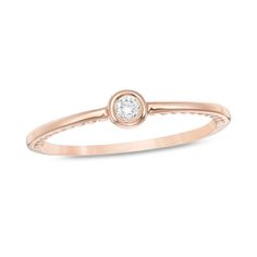 a rose gold ring with a white diamond in the center, on a white background