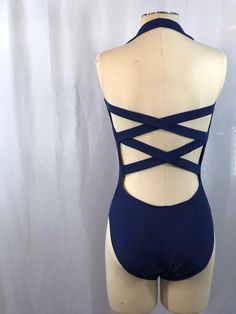 Vintage navy blue halter top swimsuit with high cuts for legs. Beautiful open back with criss cross straps. Built in shelf bra.  By Sun Streak  Size 10 Measurements when laying flat (unstretched): Underarm to underarm 13 1/2" Waist 12" Widest hip / top of leg hole 13 1/2" Crotch 4" Leg hole 9 1/2" high Top to bottom 26" Fitted Cross-tied T-back Swimwear, Backless Leotard With Lined Body For The Beach, Fitted Swimwear With Built-in Bra And Cross Back, Stretch Backless Halter Top For Beach Season, Fitted Cross-tied Swimwear With Strappy Back, Stretch Swimwear With Cross-tied Strappy Back, Stretch Backless Halter Top For Beachwear, Summer Backless Leotard, Backless Swimming Leotard With Lined Body