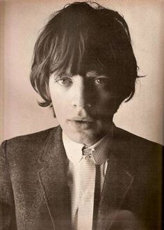 a black and white photo of a young man in a suit with his tie undone