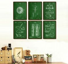 four greenprinted posters on a wall above a desk with books and other items