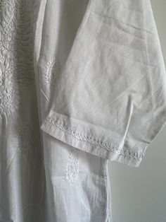 ☀️A personal favourite, get this classic piece for a timeless elegant yet casual look - hand embroidered white chikankari kurta in a pure soft cotton fabric. Light and airy, the most comfortable kurta you will ever own!    Hand made with a lot of love and attention to detail in the heart of India.    Pair it with linen pants for day out in the sun or white pyjamas for a perfect relaxed day at home.    Features embroidery on yoke, hem, back, and sleeves.    Delicate hand wash only.    NO RETURNS Cotton Kurta With Floral Embroidery And Short Sleeve, Short Sleeve Cotton Kurta With Floral Embroidery, White Mulmul Kurta With Cutwork, White Cotton Kurta With Floral Embroidery, Wedding Cotton Kurta With Lace Work, Cotton Cutwork Straight Kurta, White Bohemian Mulmul Kurta, Bohemian White Mulmul Kurta, Elegant Cotton Kurta With Chikankari Embroidery