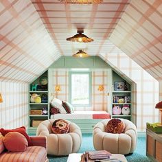 a bedroom with two chairs and a bed in the corner under a slanted ceiling