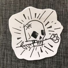 a white sticker with a skull on it