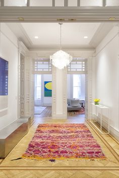 a large rug is in the middle of a room with white walls and wood floors