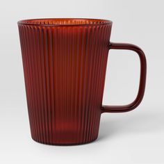 a red glass mug with wavy lines on the outside and inside, sitting in front of a white background