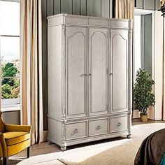 a white armoire in a bedroom next to a window