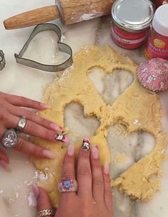 two hands with manicures are next to dough