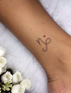 a woman's foot with a small tattoo on her left ankle and the word love written in cursive writing