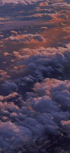 the view from an airplane window looking down on some clouds and stars in the sky