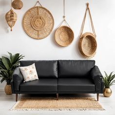 a living room with black leather couches and wicker baskets on the wall