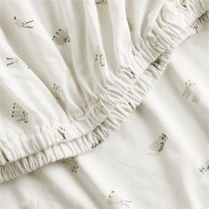 an unmade bed with white sheets and ruffled edges