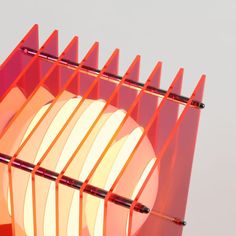 an orange and pink lamp sitting on top of a table