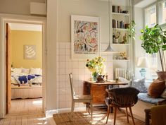 a living room filled with furniture next to a window covered in sun shining through the windows