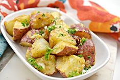 a white plate topped with potatoes covered in parsley