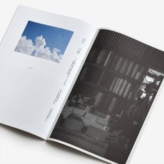 an open book with black and white photos on the pages, showing clouds in the sky