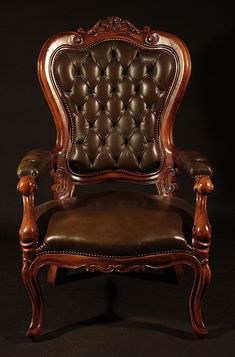 a brown leather chair sitting on top of a black floor next to a wooden frame