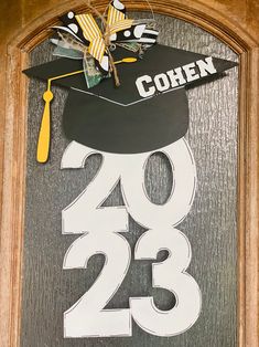 a wooden sign with a graduation cap on it