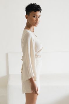 Twist it, tie it, make a loose bow or wear it off shoulder - options are endless with our sensual, multiple style Ramie Wrap Top. This top features a flowy, bell shaped full-length sleeve, and wrap tie waist which gives an ever so soft and feminine silhouette tailored to your unique body shape. Ramie is a smooth and quick drying natural fiber first used in ancient Egyptian times, and in Europe during the Middle Ages - so it’s safe to say it has stood the test of time. We love Ramie because of it Chic Tied Blouse For Summer, Chic Summer Tied Blouse, Chic White Wrap Top, V-neck Wrap Top For Loungewear, Chic Vacation Blouse With Tie Waist, Chic Wrap Top With Tie Back, Elegant Wrap Blouse For Summer, Chic Wrap Tops For Loungewear, Summer Wrap Tops With Tied Detail