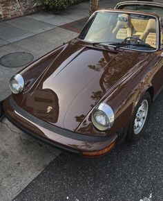 a brown sports car parked on the street