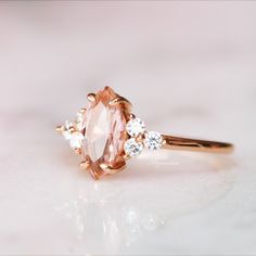 an engagement ring with a pink diamond and three white diamonds