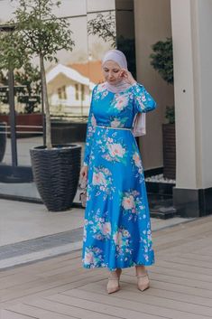 The Leena satin maxi dress from Annah Hariri is a stunning piece that combines elegant simplicity with a unique and eye-catching print Made from a polyester mix fabric this dress is both durable and comfortable to wear The dress features a zip closure at the back and buttoned sleeves, making it easy to put on and take off The dress is available in a beautiful blue color that is more saturated in direct sunlight and less shiny in dull or indoor lighting. This dress is perfect for any occasion, wh Annah Hariri, Modest Activewear, Full Coverage Swimsuit, Abaya Dress, Satin Maxi, Satin Maxi Dress, Mixing Fabrics, Active Wear Tops, Long Maxi Dress