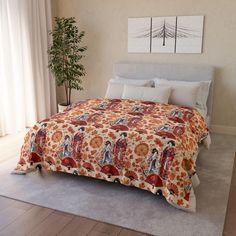 a bed in a bedroom with an orange and red bedspread on top of it