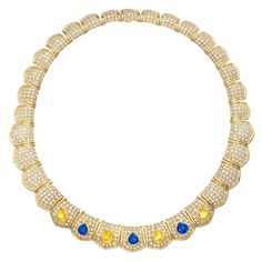 Van Cleef & Arpels dazzling collar necklace bursting with brilliance of approximately 19 carats of finest white diamonds which are complemented by 11 carats of vividly-colored blue and yellow Ceylon sapphires (GIA certified), all masterfully set in 18 karat yellow gold. The necklace is designed as a seamless series of thirty-two gold panels, each with a gracefully scalloped outer edge and pavé-set with brilliant-cut round diamonds. Each of the seven center-front panels is embellished by a large pear-shaped sapphire of richly saturated hue, alternating between yellow and blue colored sapphires. The panels gently curve from their inner to outer edge, giving maximum exposure to impeccably set diamonds and resulting in exceptional overall brilliance. The sapphires add just the right amount of Von Cleef And Arpels Necklace, Luxury Yellow Gold Necklace With Brooch, Luxury Gia Certified Yellow Sapphire Jewelry, Van Cleef Arpels Blue Necklace, Luxury Yellow Gold Necklaces With Brooch Detail, Van Cleef Arpels Emerald Necklace, Luxury Sapphire Gold-plated Jewelry, Luxury Yellow Gold Sapphire Jewelry, Bamboo Necklace