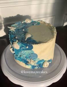 a blue and white cake sitting on top of a plate