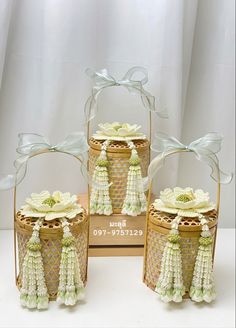 three small baskets with tassels and flowers in them