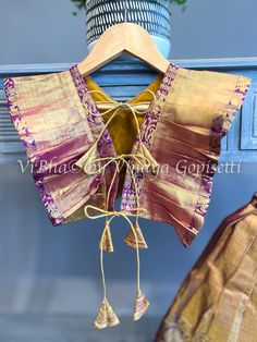 Stylish and unique, this Gold Tissue and purple Kanchi Silk Skirt and Top features a top with side ruffles and back dori handmade tassels. Perfect for cute girls, this outfit offers not only a comfortable fit, but also a one-of-a-kind style. Traditional Sleeveless Sets With Ruffles, Festive Cotton Sets With Back Tassel Tie-up, Bohemian Ruffled Sets For Festive Occasions, Bohemian Festive Ruffled Sets, Festive Bohemian Ruffled Sets, Festive Purple Ruffle Dress, Festive Purple Ruffled Dresses, Festive Purple Dress With Ruffles, Purple Ruffled Party Sets