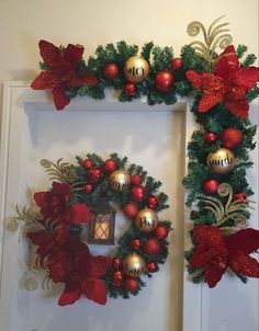 a christmas wreath with poinsettis and bells hanging on the front door frame