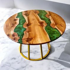 a wooden table with green and yellow designs on it's top, sitting on a marble floor