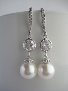 Classic cubic zirconia and pearl bridal earrings in rhodium plated brass setting. Earrings feature 10mm Swarovski white pearl drop that dangles from crystal encrusted ear wire and round cubic zirconia connector. Total length of the earrings is 4 cms . For matching necklace click: https://www.etsy.com/listing/252984768/white-pearl-and-crystal-bridal-necklace?ref=shop_home_active_7 For matching bracelet click: https://www.etsy.com/listing/253901956/classic-bridal-white-pearl-bracelet?ref=shop_home Diamond White Dangle Pearl Earrings For Weddings, White Gold Cubic Zirconia Pearl Earrings For Wedding, Classic Pearl White Cubic Zirconia Bridal Earrings, Silver Pearl Drop Bridal Earrings For Anniversary, Diamond White Sterling Silver Pearl Earrings For Wedding, Anniversary Silver Bridal Earrings With Pearl Drop, Silver Pearl Drop Chandelier Earrings, Silver Cubic Zirconia Dangle Pearl Earrings, Silver Dangle Pearl Earrings With Cubic Zirconia