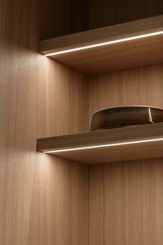 a wooden shelf with two lights above it and a light on the wall behind it