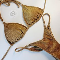 Top quality Bikini. Made in USA 2-3 week turn around time. Made to order Perfect for posing in and practicing in. Great for figure, wellness and bikini division. Also perfect for the beach and taking selfies in. Cute dainty gold rhinestone connector. Top cut is our triangle top, adjustable so you can gather top or not. Bottom back is Pro-cut and V-front cut. Top lined with cup hole for inserts. Bottom front has lining and the back is single layer, with scrunch butt to enhance glutes. Recommend- Hand wash & hang dry. No Refunds, returns and exchanges. Lining is sport lining with MaxDri moisture management & Anti-microbial Content: 80% Nylon, 20% Spandex 92%Polyester- 8% Spandex