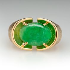 This fantastic ring is centered with one (1) oval cabochon cut natural jadeite jade set into a four-prong setting. The top half of the ring has a Florentine finish. One shoulder of the ring is engraved with initials. The ring measures 14.8mm at the top, rises 5.9mm above the finger, tapering to 4.3mm wide and 1.2mm thick at the base of the shank. This ring is currently a size 10.75. There are initials engraved on one of the shoulders in the textured gold. Formal Oval Jade Emerald Ring, Classic Oval Chrysoprase Ring, Modern Emerald Oval Cabochon Ring, Modern Oval Jade Jewelry, Modern Green Oval Cabochon Jewelry, Modern Jade Cabochon Jewelry, Modern Oval Jade Ring, Jade Rings With Polished Finish, Oval Cabochon, Jade Rings With Polished Finish In Oval Cabochon Shape