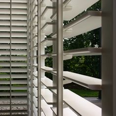 an open window with white blinds on it