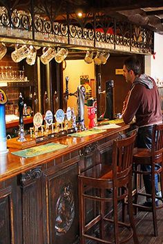 a man standing at the bar in a pub