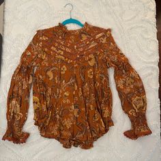 Nwt Aurora Blouse Size Medium. Sweet Ruffle Details On The Shoulders, Neck Line, Bust And Back. Ruched At The Wrists With Lace Trimmed Flare. Predominantly Rust Color With Tan And Brown Shades Throughout Orange Long Sleeve Printed Tops, Orange Printed Long Sleeve Tops, Flowy Orange Blouse With Floral Print, Flowy Orange Floral Print Blouse, Vintage Boho Print Top For Fall, Orange Long Sleeve Top With Boho Print, Orange Long Sleeve Bohemian Blouse, Fall Vintage Boho Print Tops, Orange Printed Long Sleeve Blouse