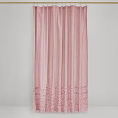 a pink shower curtain with ruffles hanging on a gold barbwire hook