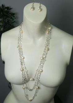 An abstract silver chain is strung to clear beads and brushed cream pearls to form this lovely set. Featuring unique diamond silver chain details and clear gems that are plated around the crystal! These two pieces are magnificent and are sure to stand out! Handmade and supports future art! Elegant Multi-strand Beaded Chain Jewelry, Party Silver Jewelry With Pearl Chain, Silver Pearl Chain Jewelry For Party, Silver Pearl Jewelry For Party, Sterling Silver Pearl Chain Jewelry For Party, Silver Beaded Long Pearl Necklace, Pearl Beaded Chain Dangle Jewelry, Elegant Metal Pearl Necklace With Beaded Chain, Silver Beaded Pearl Necklace For Parties