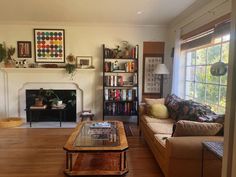 a living room filled with furniture and a fire place in front of a large window