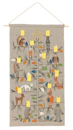 an embroidered wall hanging with animals and plants on the front, along with yellow sticky notes attached to it