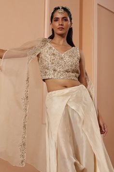 Ivory blouse featuring floral embroidery and tie-up detailing on the back. Paired with a draped dhoti and embroidered sheer cape. - Aza Fashions Silk Dupatta Top For Wedding, Silk Top With Dupatta For Wedding, Silk Wedding Top With Dupatta, Traditional Drape Embroidered Raw Silk Top For Wedding, Elegant Raw Silk Embroidered Top For Wedding, Wedding Embroidered Raw Silk Top With Traditional Drape, Elegant Embroidered Raw Silk Top For Wedding, Tissue Silk Top For Wedding, Fitted Tissue Silk Tops For Wedding