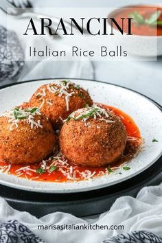 three meatballs covered in tomato sauce and parmesan cheese on a white plate