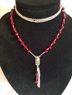 "This handmade Virgen De Guadalupe Necklace is made using Silver Tone curb chain that has triple layer and strung on 2 jump rings. Next are hand beaded individual links that connect to 12 connectors. At the bottom is a Silver Tone Medal of La Virgen De Guadalupe and on the reverse side has the wording \"Our Lady of Guadalupe\". Below that is a small jump ring with 4 2 1/2\" Chains with 2 chain and bead connector. All material used is new and non-vintage items. This necklace will arrive in a gift Red Double Strand Beaded Chain Jewelry, Red Beaded Double Strand Jewelry, Red Double Strand Beaded Jewelry, Red Multi-strand Beaded Chain Jewelry, Adjustable Red Beaded Chain Choker, Adjustable Red Beaded Choker, Guadalupe Necklace, Rosary Style Necklace, Our Lady Of Guadalupe