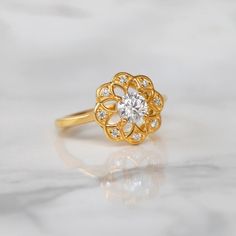 Sometimes when a girl says she likes to receive flowers as a gift, it's not the real flowers she means. Think twice and go for the safest thing - our Flora ring with Moissanite. Floral jewelry is where it's at! Perfect as a graduation gift, birthday gift, anniversary ring, or a promise ring. Details: Center stone Gemstone: Moissanite Stone Shape: Round Measurements: 5.00mm Side stones Gemstone: Moissanite Shape: Round Measurements: 1.30mm (8) Band measurements: approx. 1.8mm wide, approx. 1.5mm Halo Diamond Ring For Proposal, Halo Diamond Ring Gift Round Cut, Halo Diamond Ring Gift, Round Cut, Round Cut Halo Diamond Ring Gift, Flower Shaped Diamond Ring For Wedding, Wedding Diamond Ring With Prong Setting In Flower Shape, Diamond Flower Shaped Ring With Prong Setting For Wedding, Halo Moissanite Diamond Ring Gift, Dazzling Diamond Ring With Halo Design For Gift